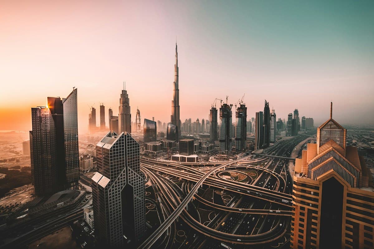 The Burj Khalifa and Dubai skyline above a motorway interchange at sunrise